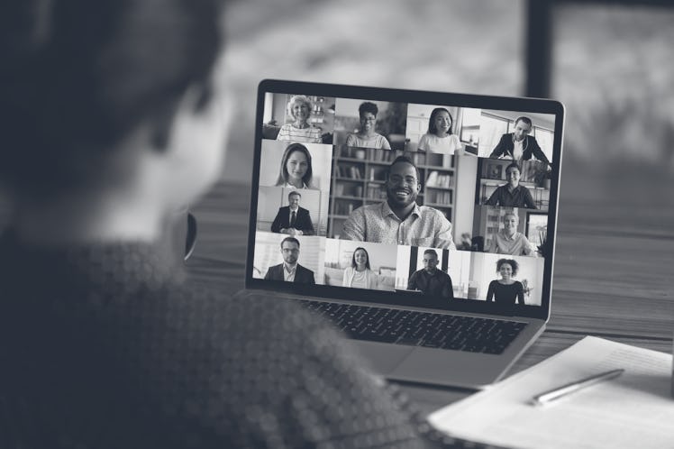 Over shoulder view of female worker on a digital virtual conference with colleagues.
