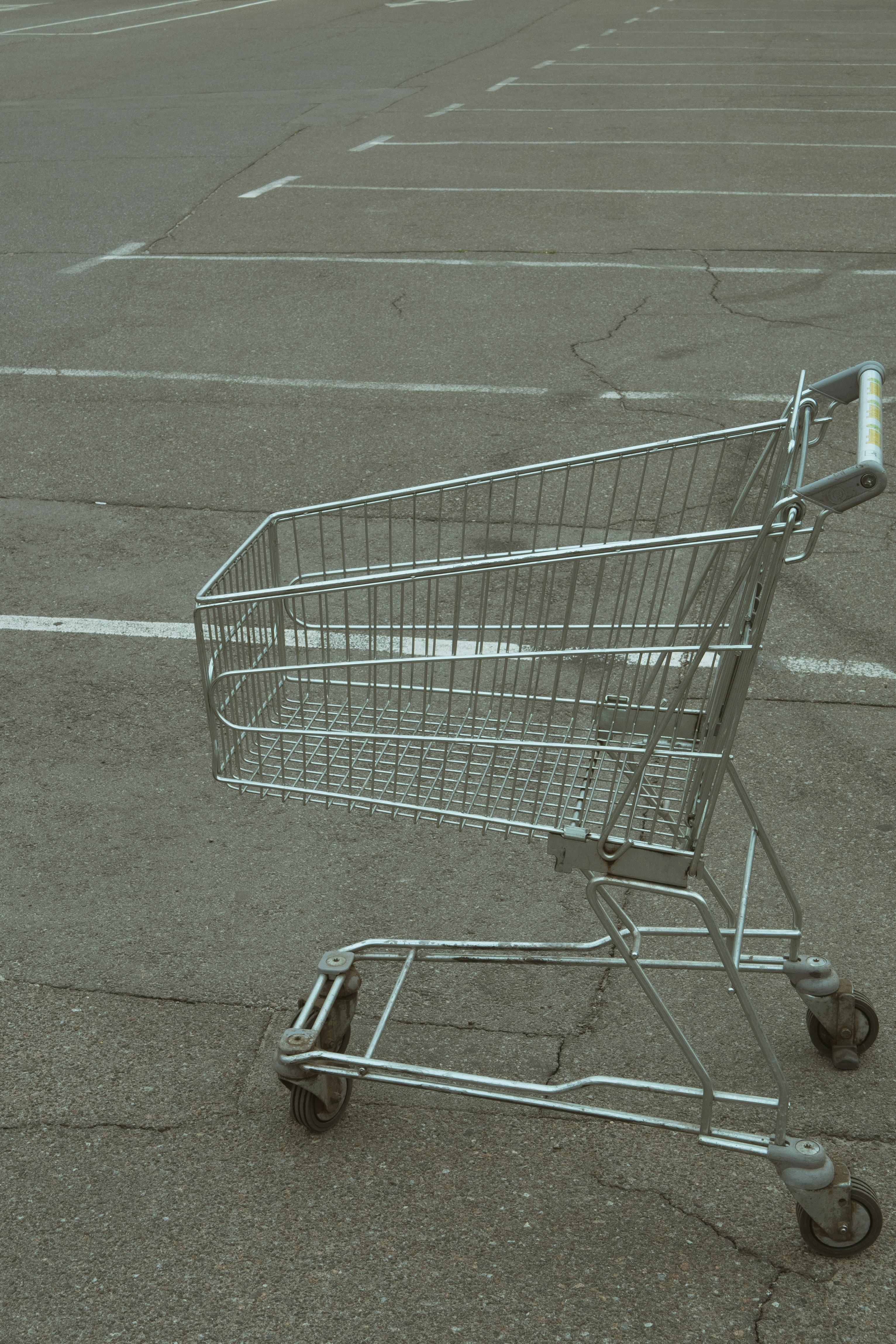 close up of empty shopping cart at parking near grocery store. crisis customers can't afford buying ...
