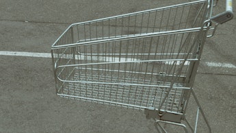 close up of empty shopping cart at parking near grocery store. crisis customers can't afford buying ...