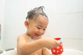 smiling asian baby child boy play with toy at bathtub in bathroom, cute asian toddler boy with funny...