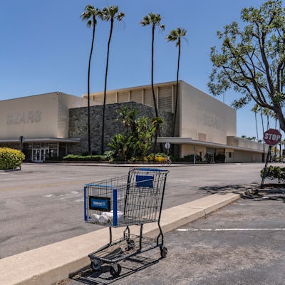 This, photo shows an empty shopping cart in an empty parking lot at the closed Sears in Buena Park M...