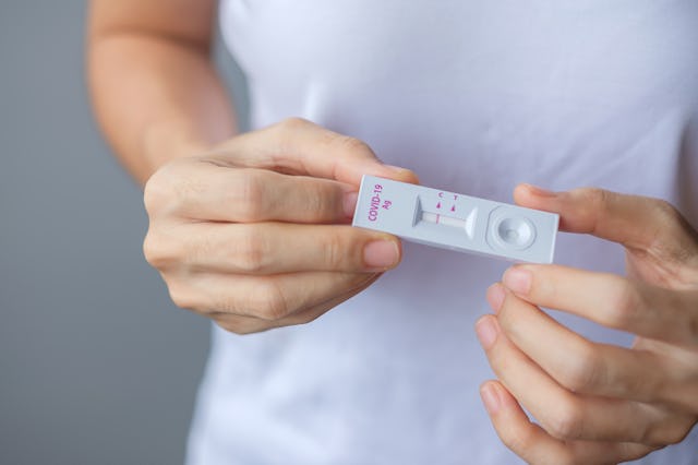man holding Rapid Antigen Test kit with Negative result during swab COVID-19 testing. Coronavirus Se...