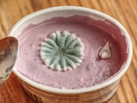 Moldy yogurt on a wooden table background.  Poisoning breakfast