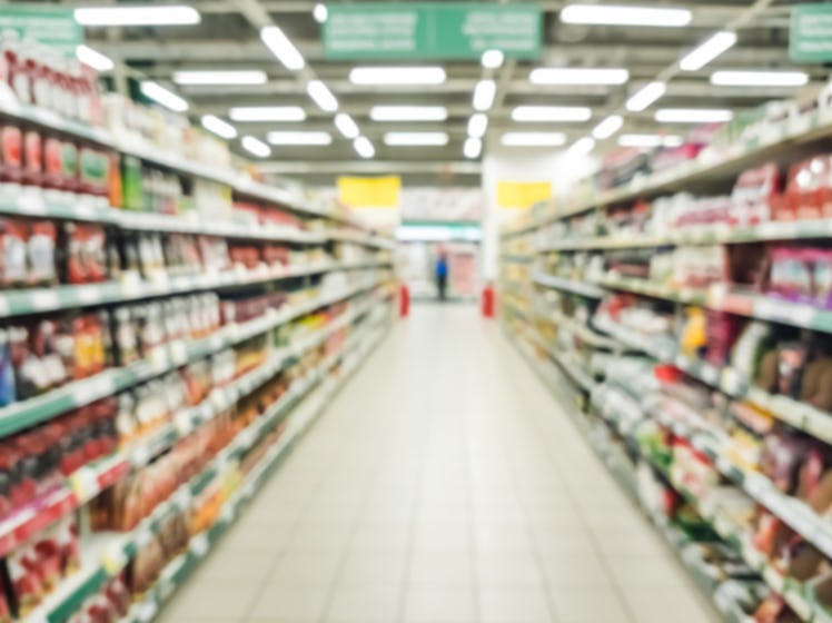 Blurred supermarket aisle with colorful shelves of merchandise. Perspective view of abstract superma...