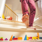 Man walking down staircase filled with children's toys