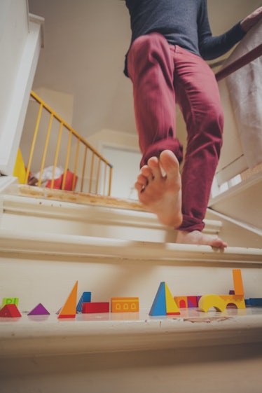 Man walking down staircase filled with children's toys