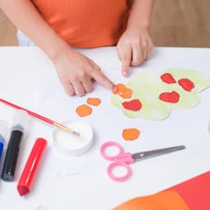 Top view of little 3 years old toddler boy enjoy using glue doing arts at home, Fun paper and glue c...