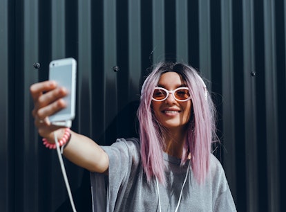 Young beauty girl purple hair make selfie on smartphone, happy face, outdoor hipster portrait on the...