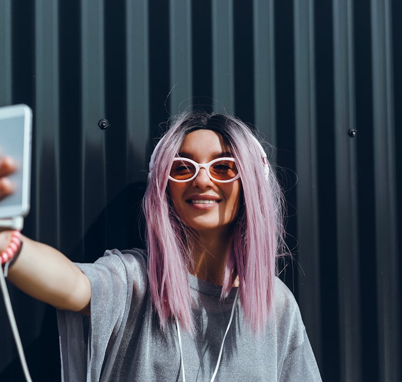 Young beauty girl purple hair make selfie on smartphone, happy face, outdoor hipster portrait on the...