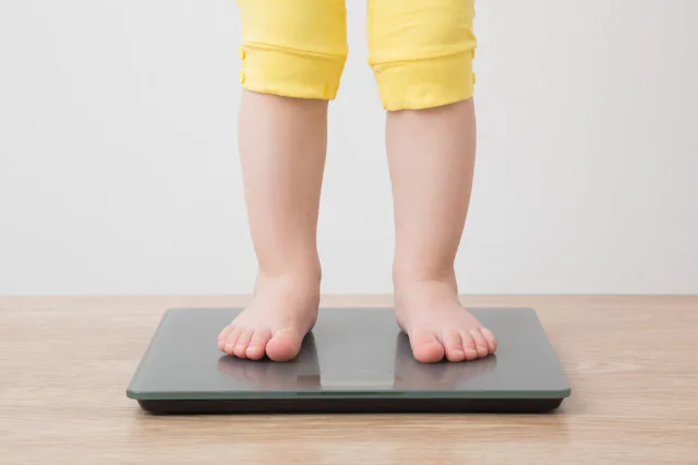 A child stands on a scale. A new study has found rising rates of childhood obesity.