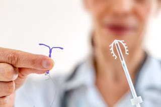 Female doctor holding two knd of intra utreine devine for birth control