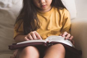 Asian kid girl read bible study.Worship at home.Sunday school.Bible on kid hands.Family christian ,R...