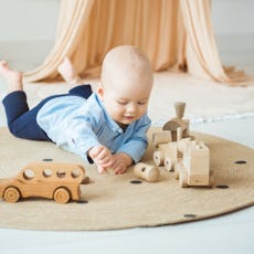 Baby playing with wooden toys. Eco-friendly wooden toys for children