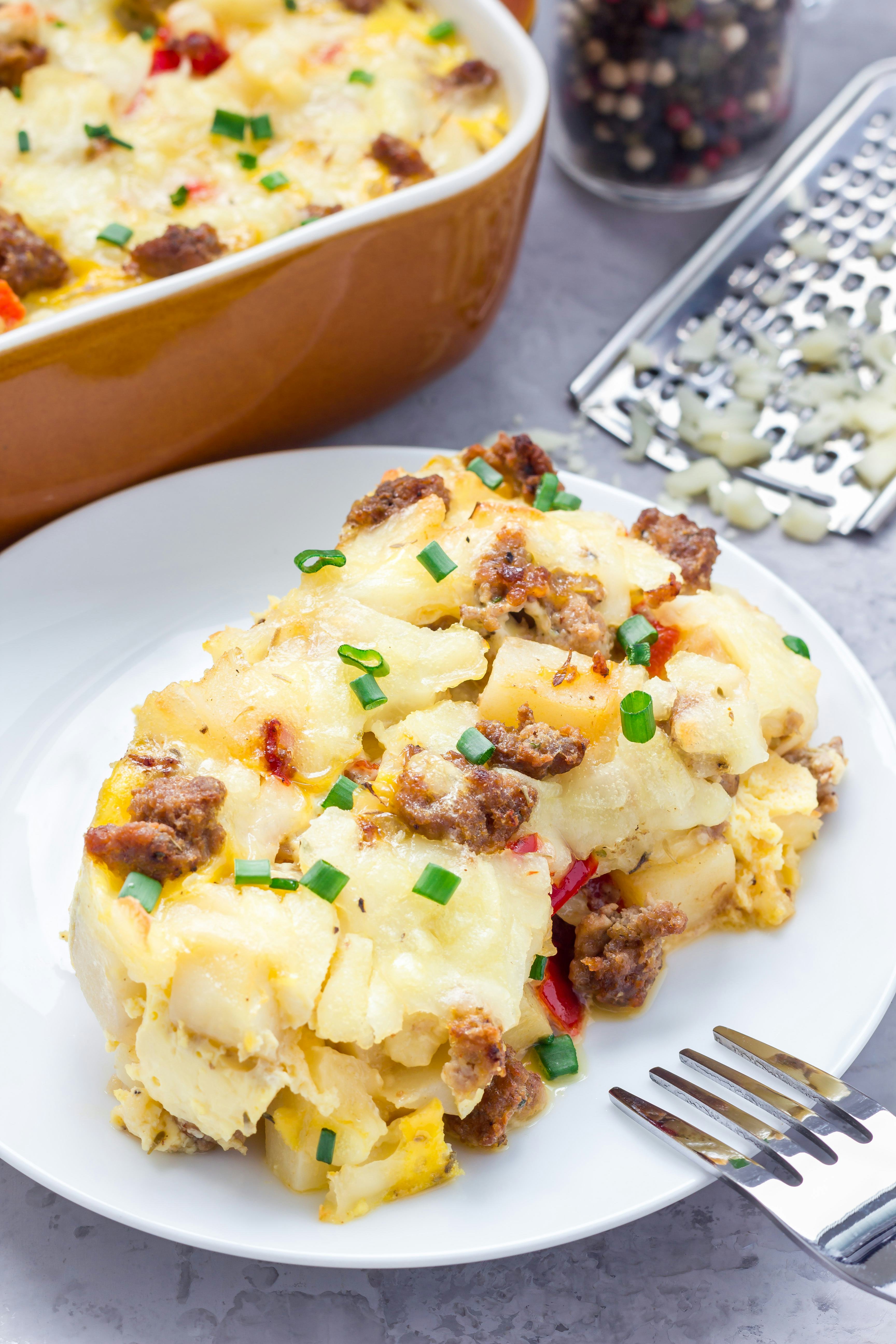 Egg casserole with potatoes, sausage and pepper, on white plate, vertical