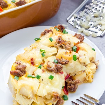 Egg casserole with potatoes, sausage and pepper, on white plate, vertical