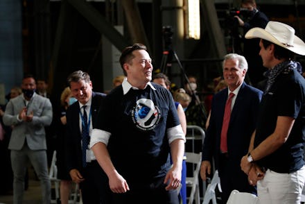 Tesla and SpaceX Chief Executive Officer Elon Musk stands as his brother Kimbal Musk, right, and Hou...