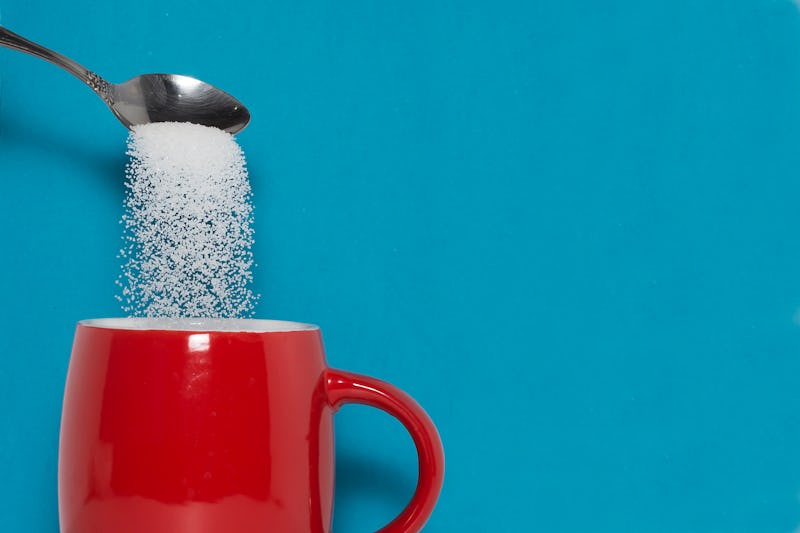 teaspoon puts sugar in a cup. The concept of the dangers of excessive consumption of sugar. Diabetes...