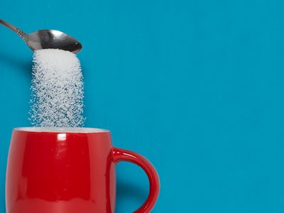 teaspoon puts sugar in a cup. The concept of the dangers of excessive consumption of sugar. Diabetes...