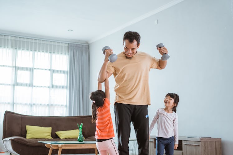 kid disturb his daddy while doing sport at home