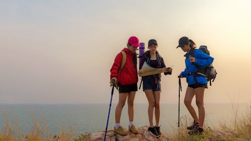 Group asia friends traveler with backpack adventure holding map to find directions and walking relax...