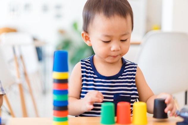 toddler boy playing stacking cups