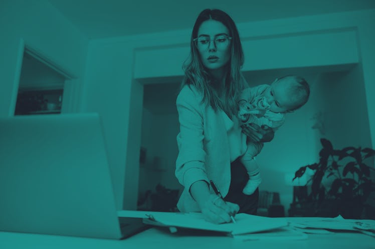 Design professional making notes while holding her baby. Multitasking mom planning a new project in ...