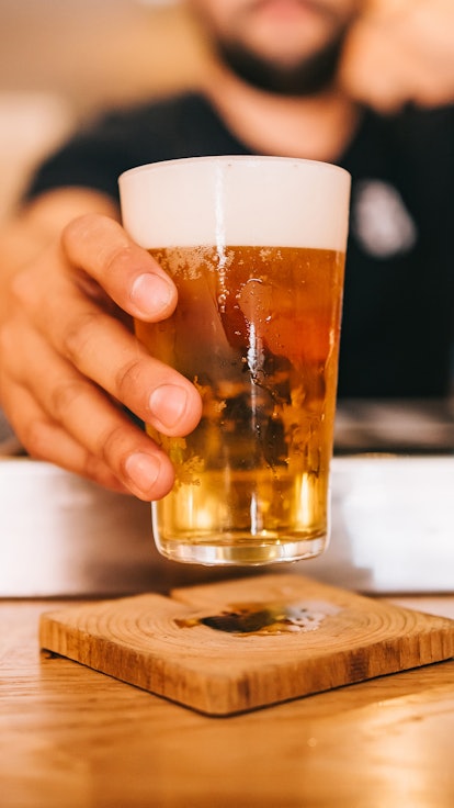 Freshly tapped beer. Bartender holding a freshly tapped glass of beer in his hand