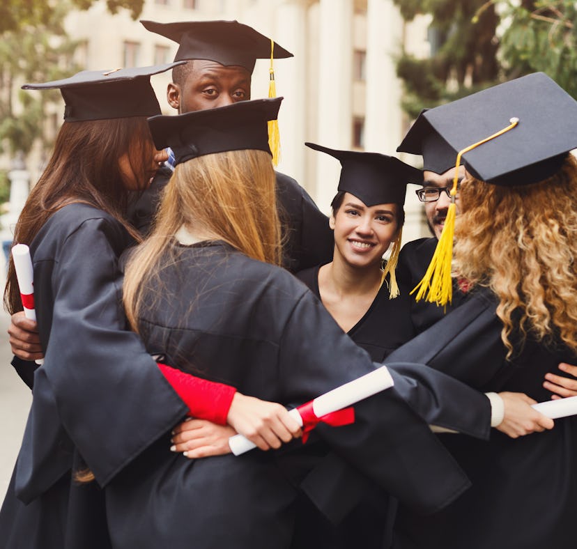 Group of multietnic students hugging on their graduation day at university, copy space. Education, q...