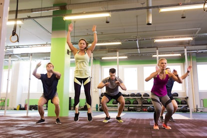 A group doing burpees together in a gym.