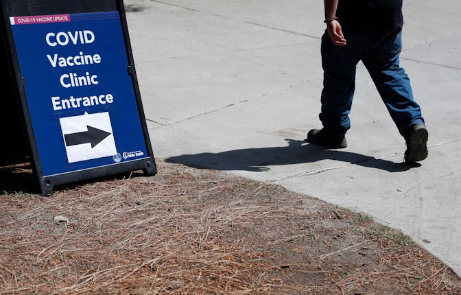 A person walks by a sign for a vaccination clinic at Eugene A. Obregon Park in Los Angeles, Californ...