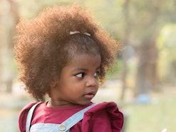 Close up portrait of a toddler girl in the park in an article about baby names that start with W