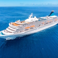 Cruise liner ship in ocean with blue sky. Aerial top view.
