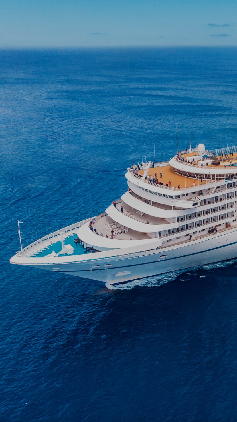 Cruise liner ship in ocean with blue sky. Aerial top view.