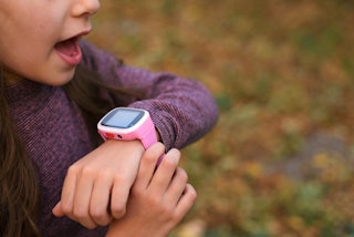 Smart watch on the child's hand. Girl kid includes smart watches finger.