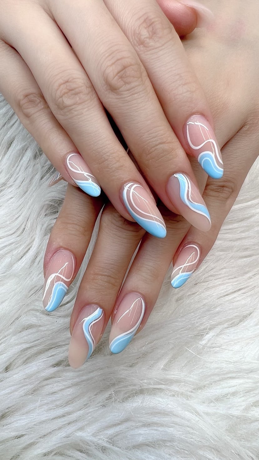 Swirl nails with abstract art in blue and white, one of the biggest nail trends for 2023.
