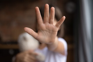 Crop close up of little girl child stretch hand show no gesture protest against domestic violence. S...