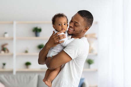 Father And Child. Happy Young Black Dad Embracing Cute Little Baby Boy While They Posing Together In...