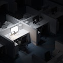 Top view of white office cubicle with mock up computer screen standing in modern office at night. Co...