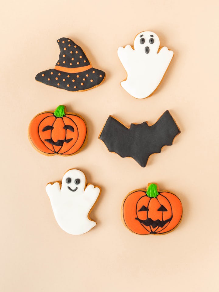 Various Halloween gingerbread cookies - Jack O'Lanterns, ghosts, bat and black hat on beige backgrou...