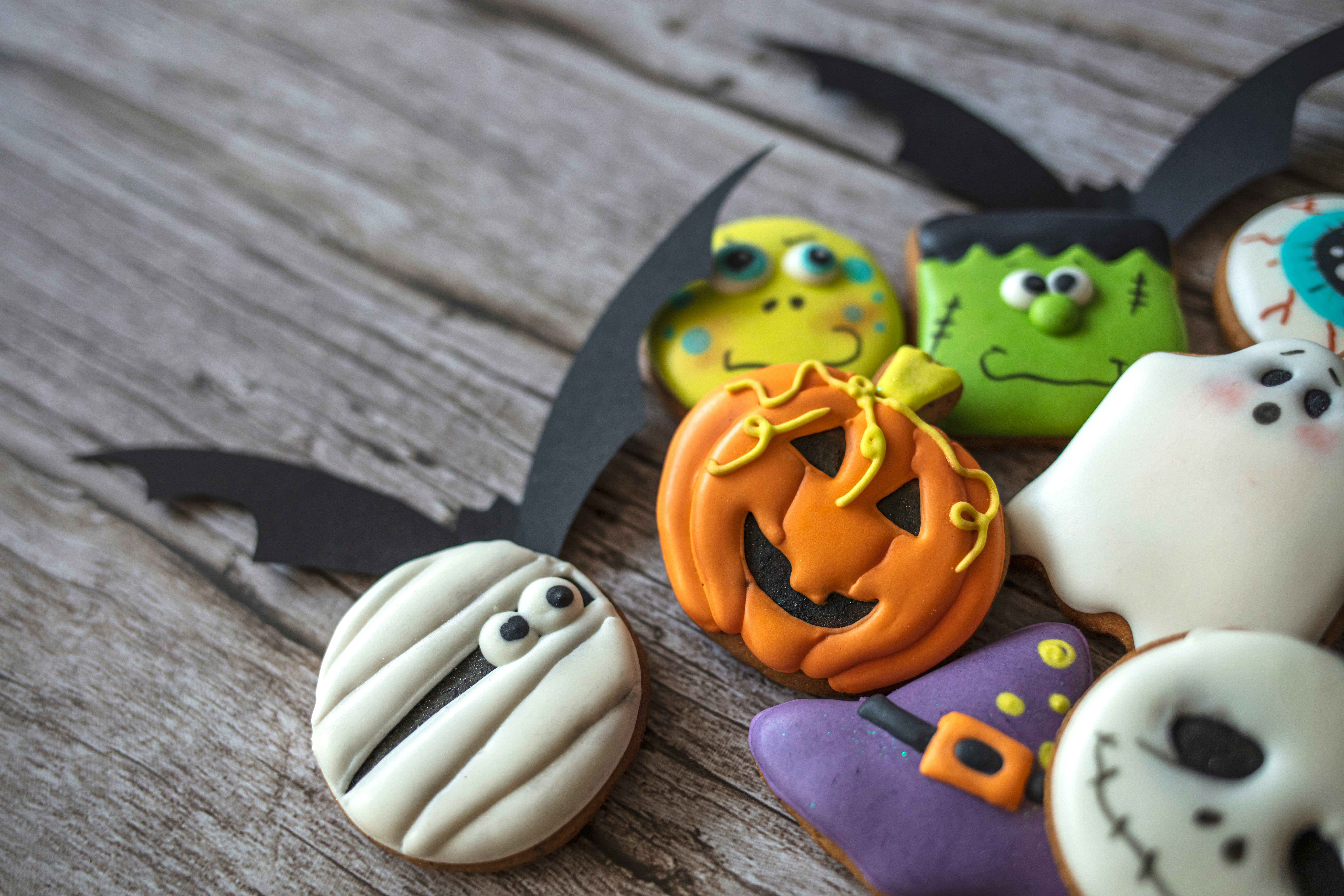 Halloween gingerbread cookies in plate on wooden table. The hand-made eatable gingerbread Halloween ...