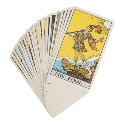 A deck of tarot cards in the style of Rider-Waite-Smith, depicting the Fool card on top.