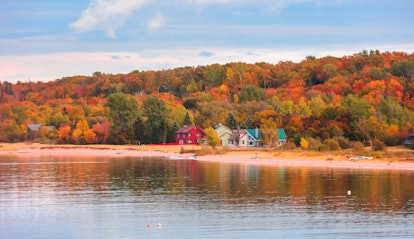Colorful homes at the Lake Superior shore surrounded by Fall foliage in Michigan
