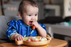 baby eating finger food as part of baby led weaning
