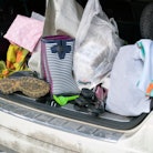 Open car trunk with personal belongings in mess, outdoor close-up