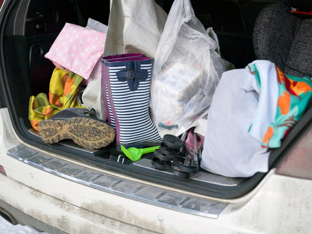 Open car trunk with personal belongings in mess, outdoor close-up