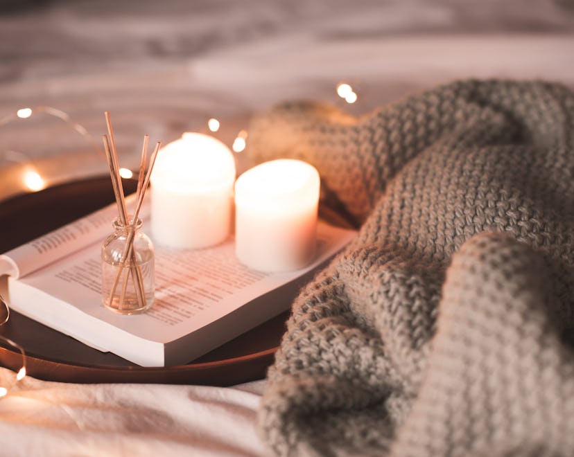 a fall scene with books and lit candles Bath & Body Works Fall Candle Instagram Captions
