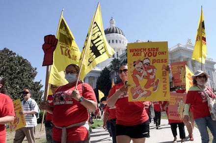 Fast food workers and their supporters march past the state Capitol calling on passage of a bill to ...
