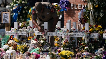 State trooper places a tiara on a cross honoring Ellie Garcia, one of the victims killed in this wee...