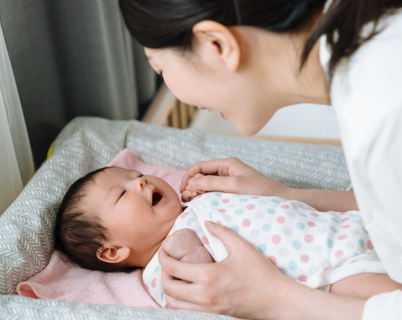 portrait of asian baby feeling comfortable after changing diaper and laughing to her mother happily....