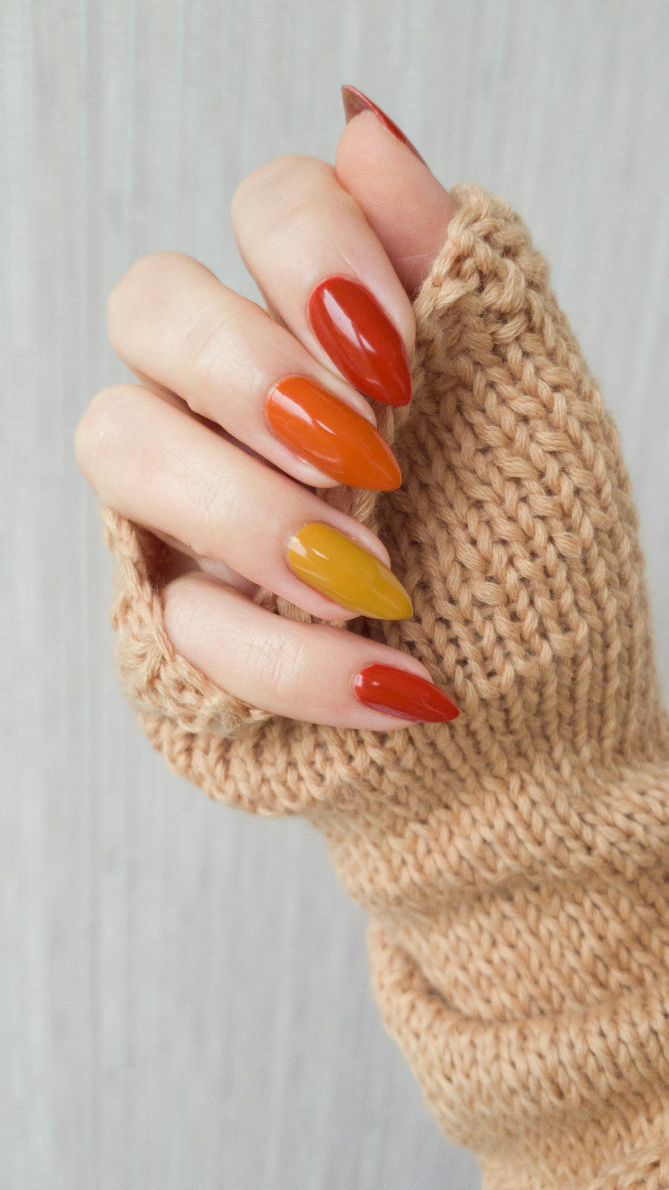 Female hands with long nails with yellow golden nail polish